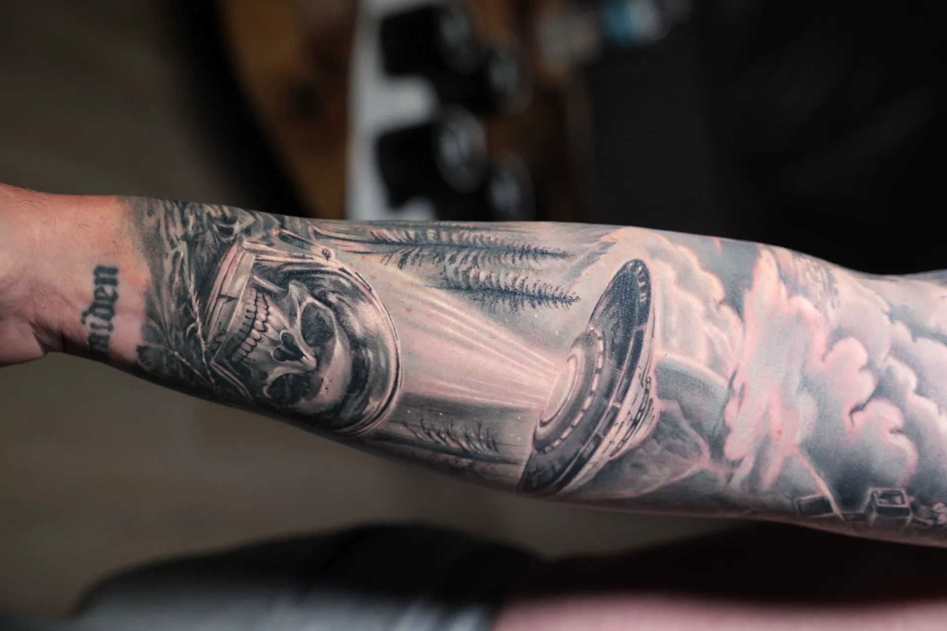 Black-and-grey realism forearm with a crowned skull and sunburst clouds — Hector Rodriguez Goderich